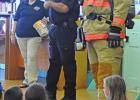 Members of the Hughes Springs Volunteer Fire Department visit with children at the Hughes Springs Area Library June 10. Charles Pribble (right) shows children how a fireman would look during a fire. Back with a Splash!