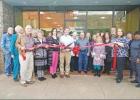 BEE PHOTO / TRISHA CAREY Philip Chapman, center, cuts the ribbon at the new location for his company, East Texas Investments. East Texas Investments, now located at 205 East 1st Street in Hughes Springs, held their grand opening on Feb. 25 with members of Article Image Alt Text