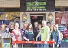 BEE PHOTO / TONI WALKER Amanda and Josh Sanders, center, cut the ribbon on their newly opened store front for Start2Finish. They are surrounded by members of the community and Chamber of Commerce Board members. The storefront is located on Coffey Street. Article Image Alt Text