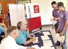 Chad Elledge and Hayden Luker, with Texas Heritage National Bank, advise Work4College students on their technology budget during the Money Matters financial literacy event Courtesy photo Chad Elledge and Hayden Luker, with Texas Heritage National Bank, advise Work4College students on their technology budget during the Money Matters financial literacy event Courtesy photo