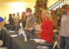 Members of the Hughes Springs Chamber of Commerce assist visitors registering for Holiday on First Street at The Legacy Event enter Nov. 23. Sixteenth annual Holiday on First Street follows Christmas Trees in the Park to open HS holiday season