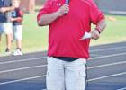 Hughes Springs Head Coach and Athletic Director Chris Edwards speaks to the crowd prior to introducing the football teams at the school’s annual Mustang Stampede on Aug. 12. Fans fill Mustang Stadium for