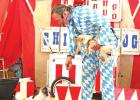 Darren Peterson performs with two of his dogs, Skeeter and Squirrel, as Laurn Macaw, a scarlet macaw, keeps an eye on the action from above. Peterson and his animals presented the Circus Chickendog show at the Hughes Springs Public Library June 24. See mo Circus Chicken Dog wows children at Hughes Springs Library