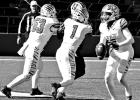 Daingerfield Tiger quarterback Chase Johnson (0) looks downfield for an open receiver while teammates Treston Smauley (53) and Ashton Williams (1) pick up a block. Johnson torched the Eagle defense for 304 yards passing and 61 yards rushing with five touc